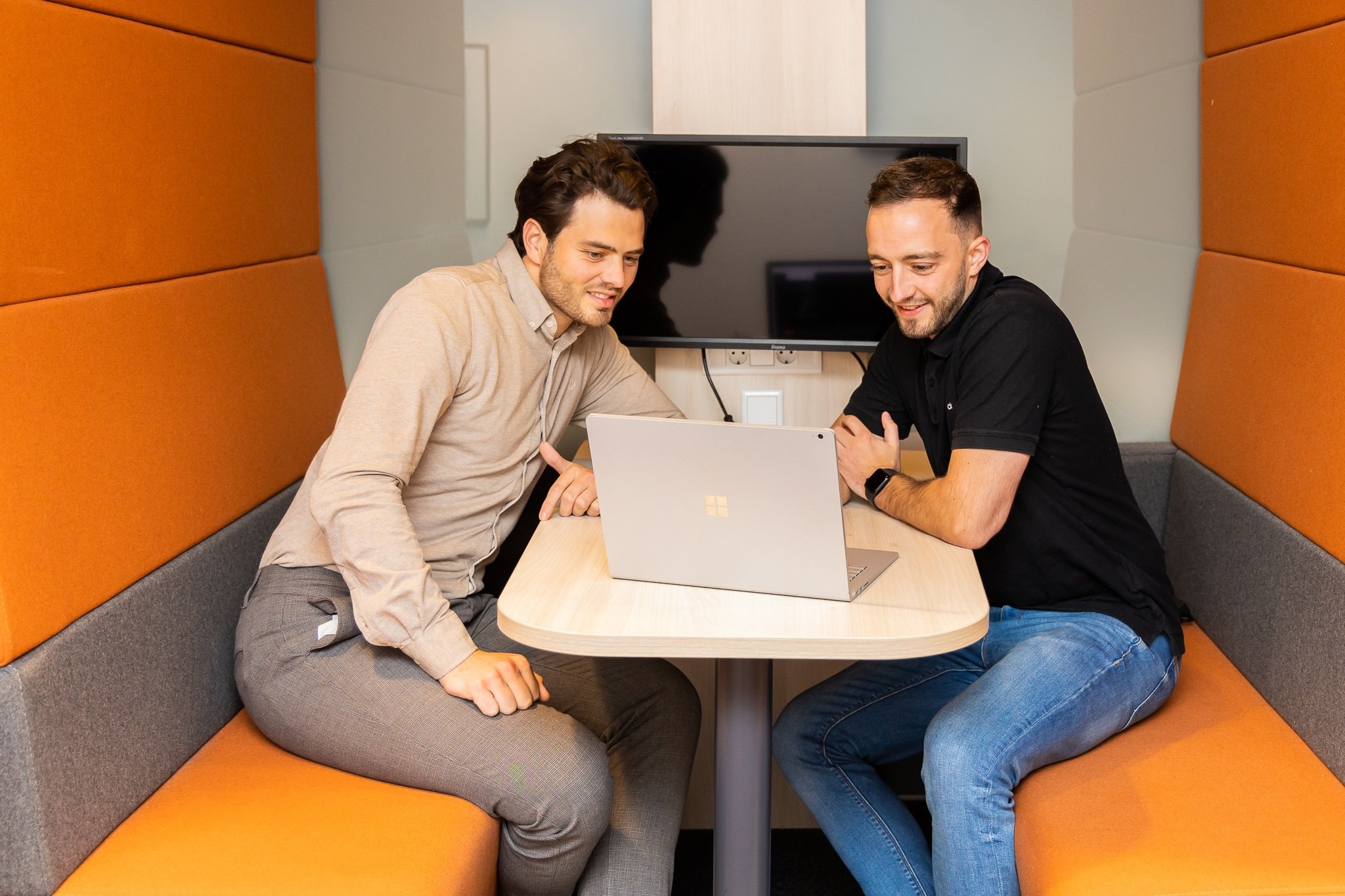 Twee mannen kijken op laptop naar aanbod Academy